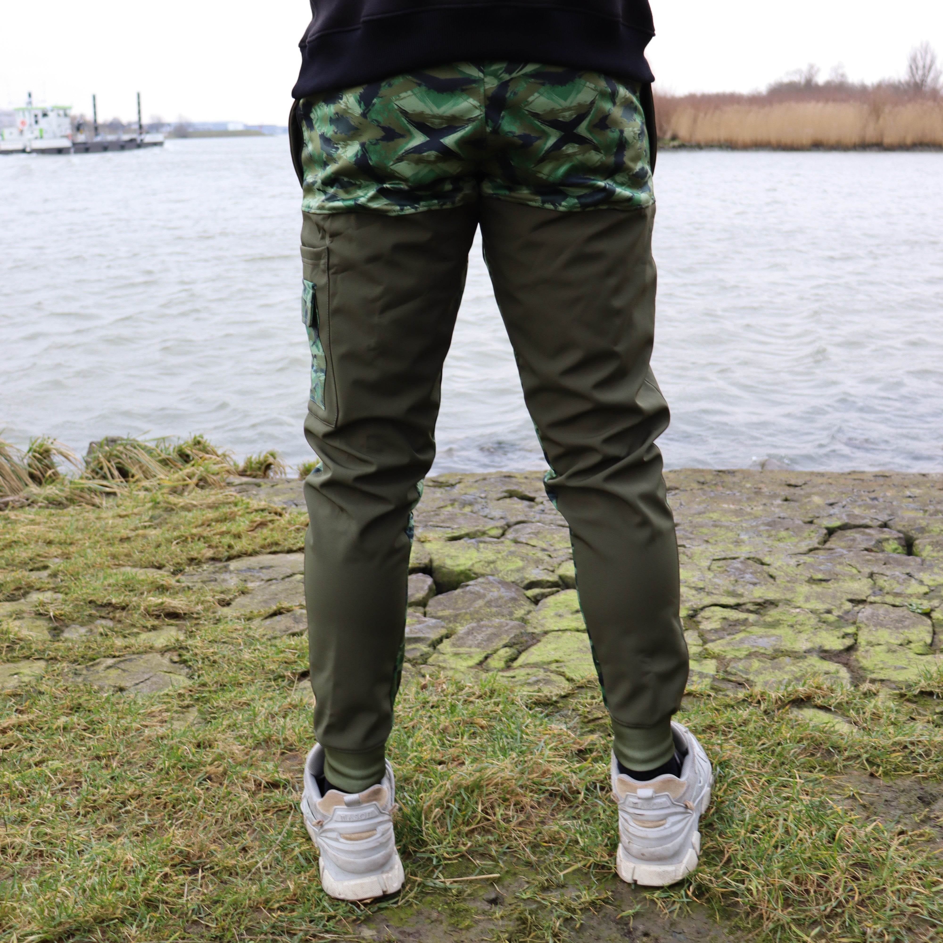 Achterkant van de River Crew Softshell Adventure Trousers, met verstevigde stof en een comfortabele pasvorm voor vissers en avonturiers.