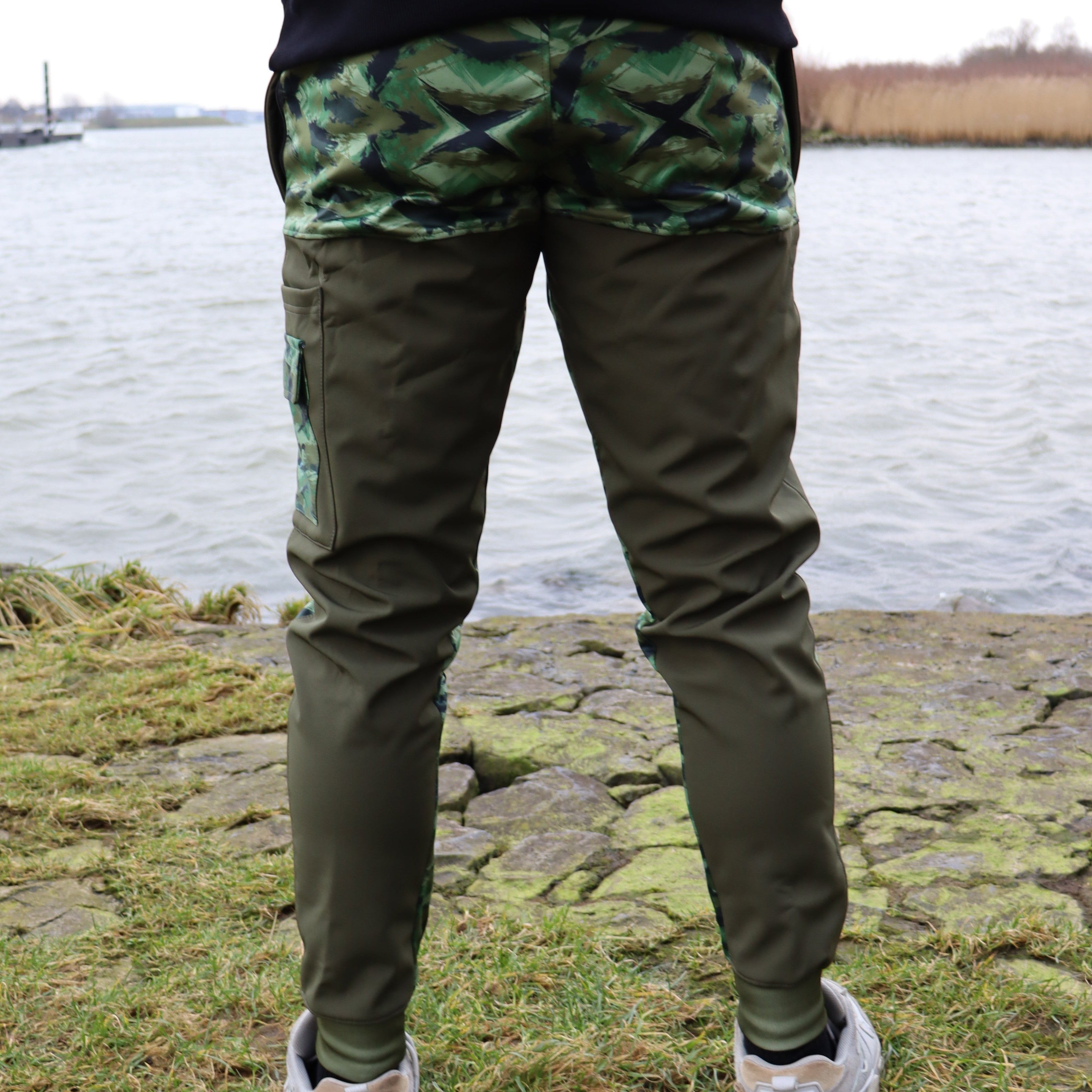 Achterkant van de River Crew Softshell Adventure Trousers, met verstevigde stof en een comfortabele pasvorm voor vissers en avonturiers.